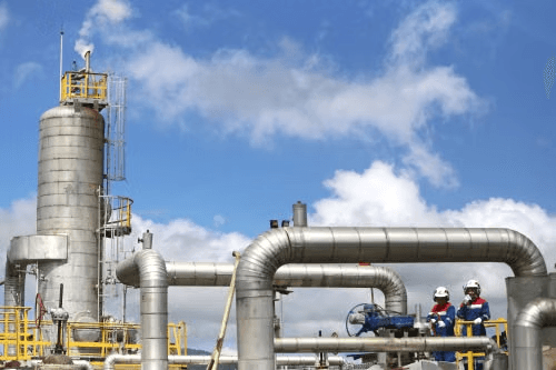 Engineers inspecting a process column and piping